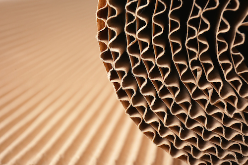 Closeup view of roll of brown corrugated cardboard, space for text. Recyclable material
